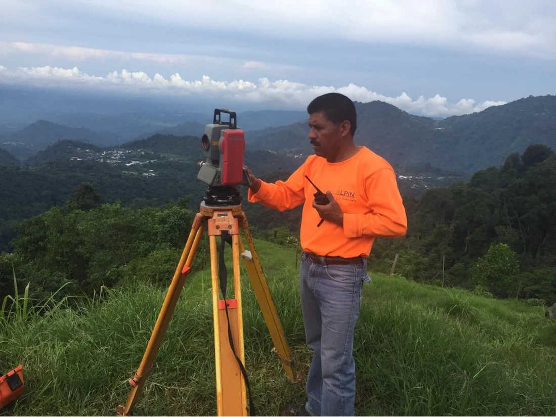 Integrante del equipo realizando mediciones topográficas en un entorno montañoso